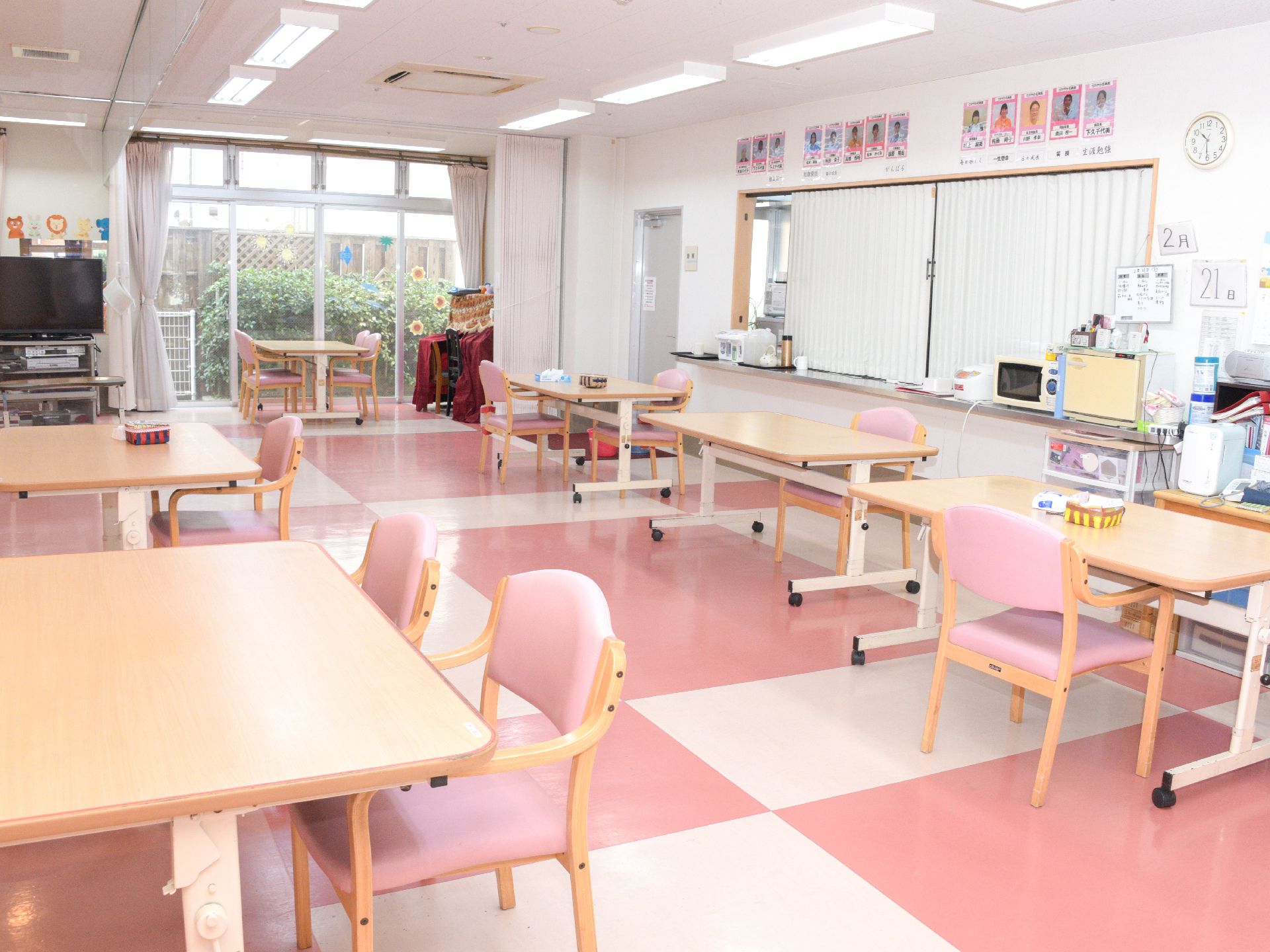 食堂は車いす利用者の方も同じテーブルで食事を摂れるように充分なスペースを確保。窓から光も充分に差し込む空間でピンクと白でまとめられている。