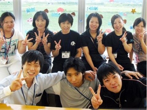 2列に並んで笑顔でポーズをとっている、9名のスタッフたち