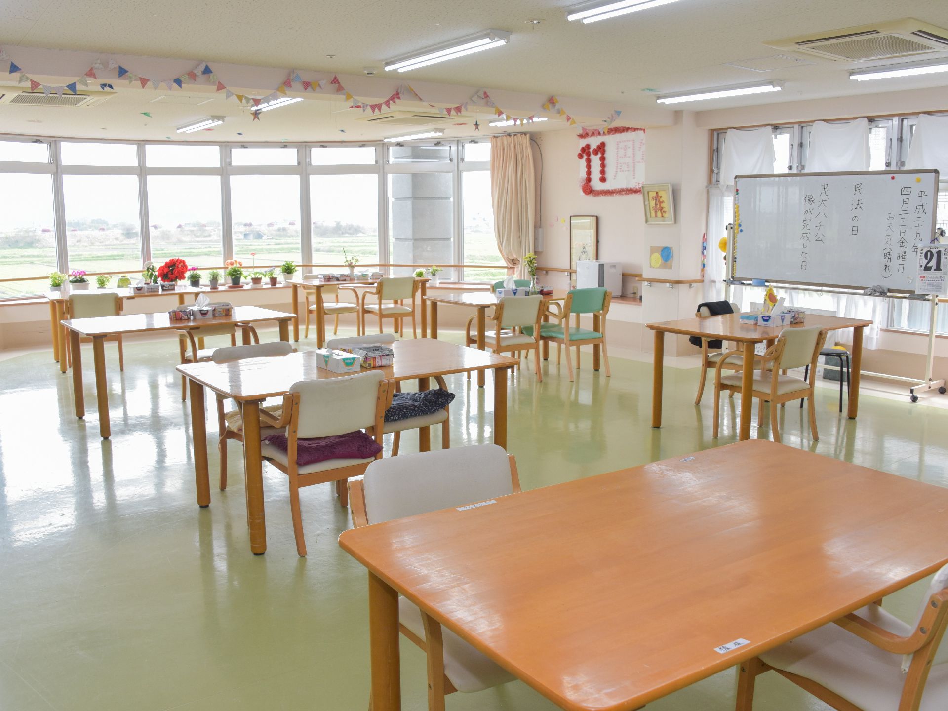 飾りつけがしてあり、明るい雰囲気の広々した空間。テーブルといすが設置してあるので、入居者同士の交流や趣味・創作活動など色々と利用できる。