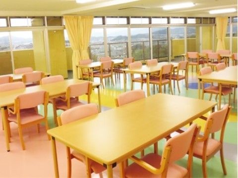 「住宅型有料老人ホームさわやか立花弐番館」ダイニング。カラフルな床の上に四人がけのテーブルが並びます。