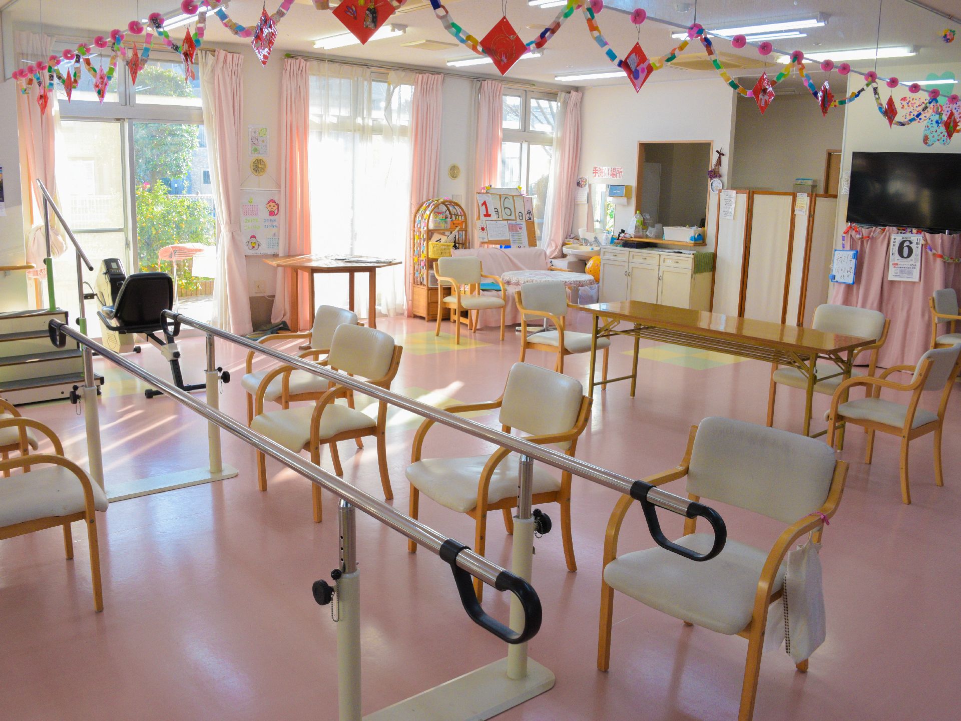 カラフルに飾りがついた部屋に、歩行訓練などができる平行棒とバイク運動器具、そして昇降運動ができる数段の階段が設置されている。