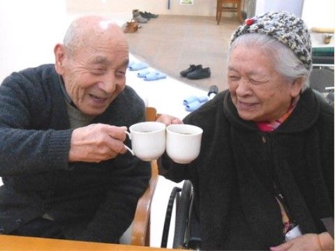 白いティーカップを手に、乾杯をしている男女の入居者様