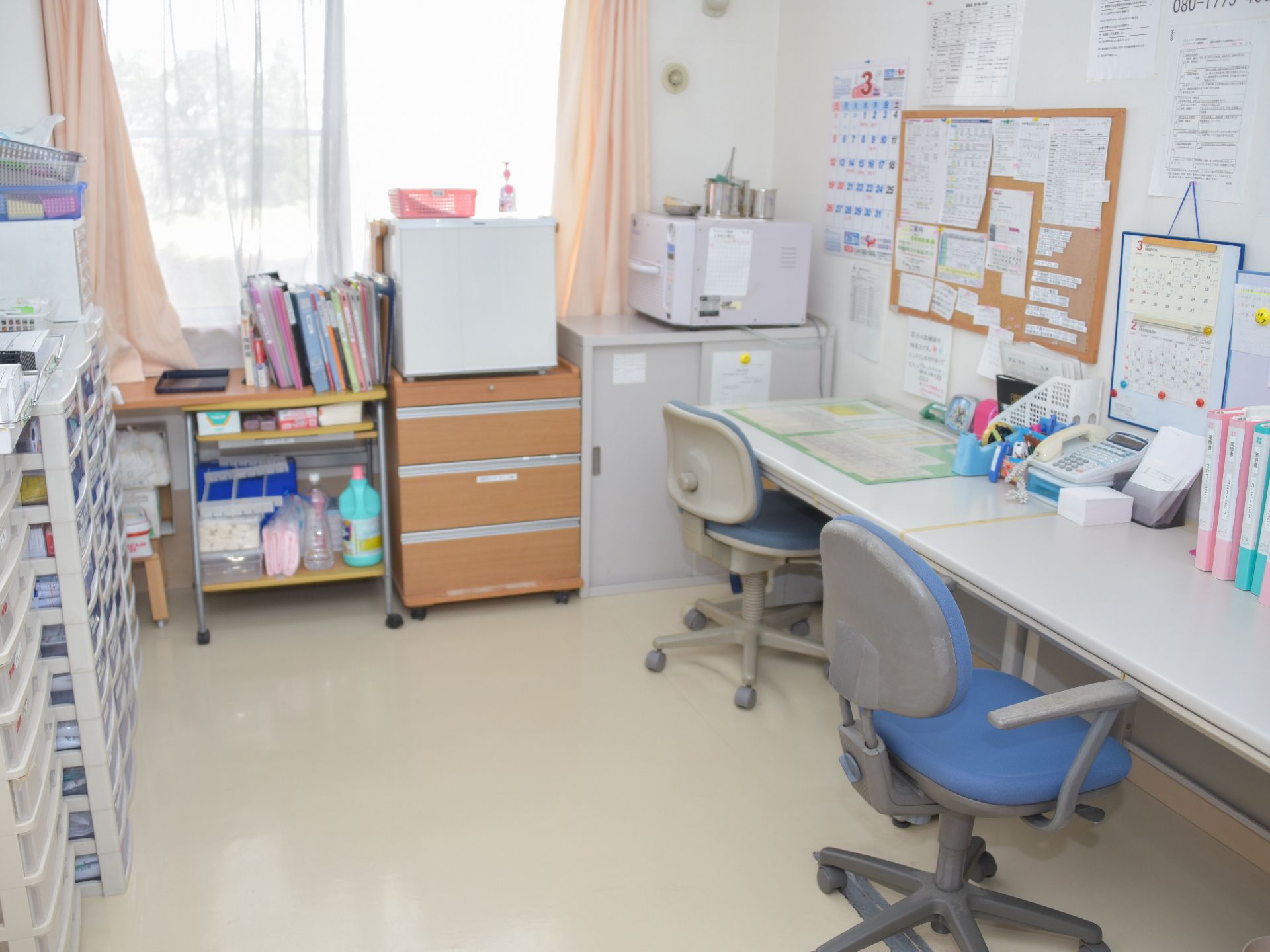 事務所ではファイルが整頓されており、備品類も棚に収納されている。コルクボードを活用し情報を整理している。