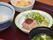 ハンバーグにピントを合わせた食事の写真。租借しやすいようにしっかり練り込まれているのがわかる。上にデミグラスソースがのっている。