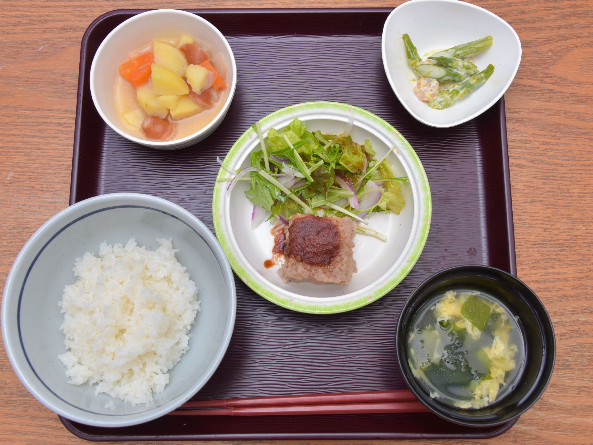食事サービスの一例。この日の献立は、ご飯、かきたま汁、ハンバーグとサラダ、じゃがいもと人参の煮物、緑の副菜。