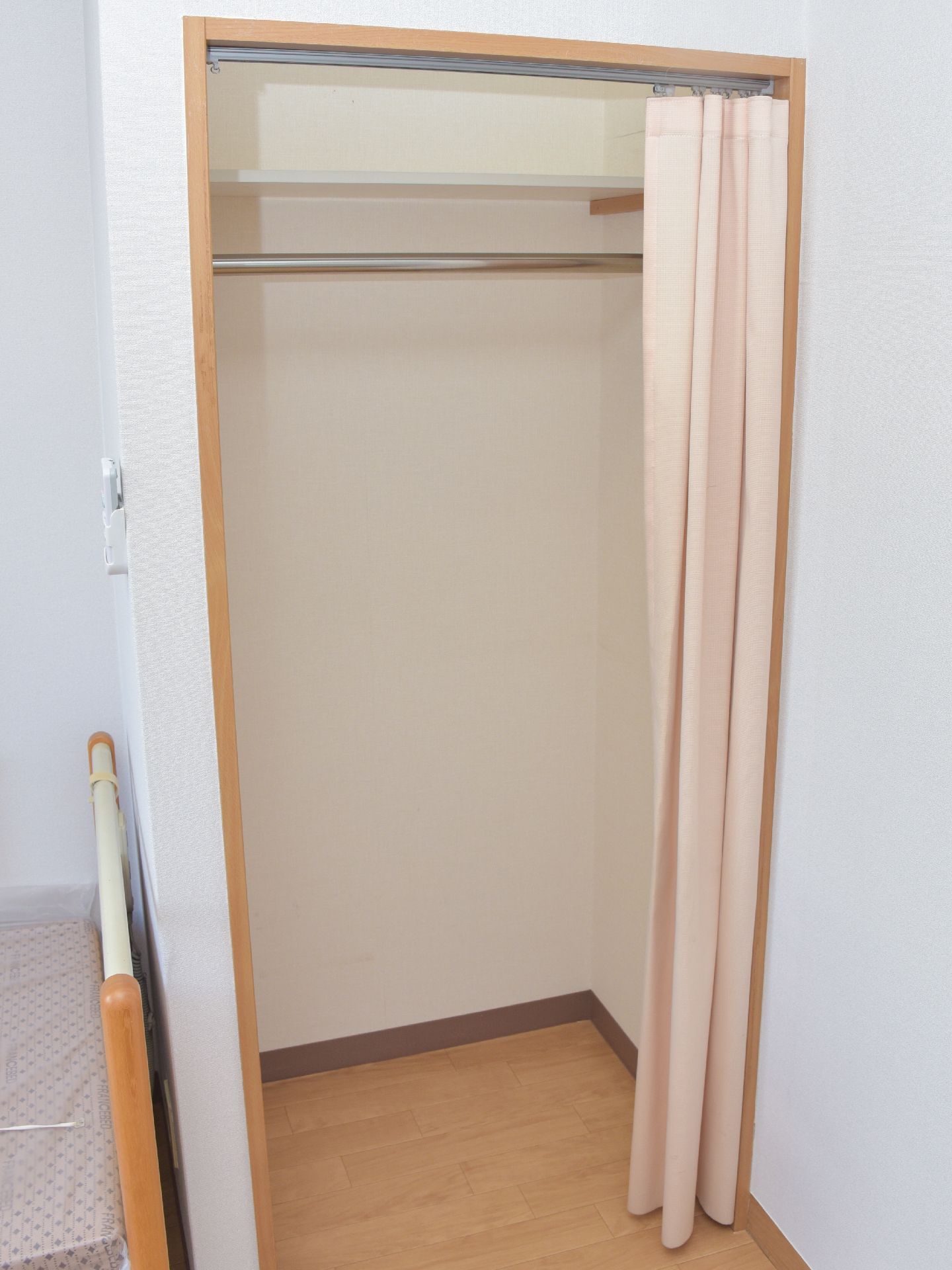 居室内にあるクローゼットは、扉がカーテン式になっている。上方に棚があり、その下に洋服を吊るせるようになっている。