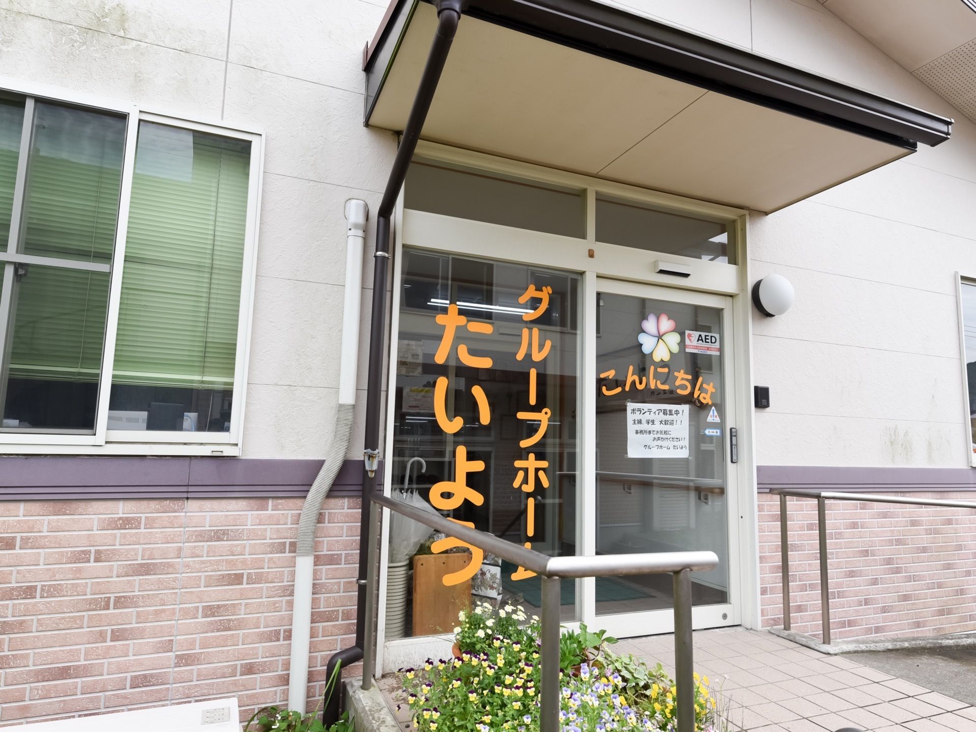 スライドドアで入口は広々としている。大きなホーム名はインパクトがありつつも、色や字体から温かみを感じる。
