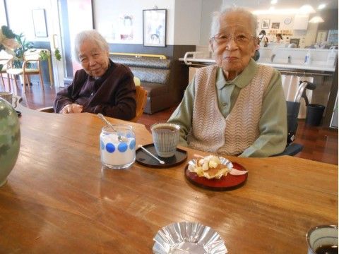 机の上にお茶とおやつが用意されており、カメラ目線の2人の入居者様
