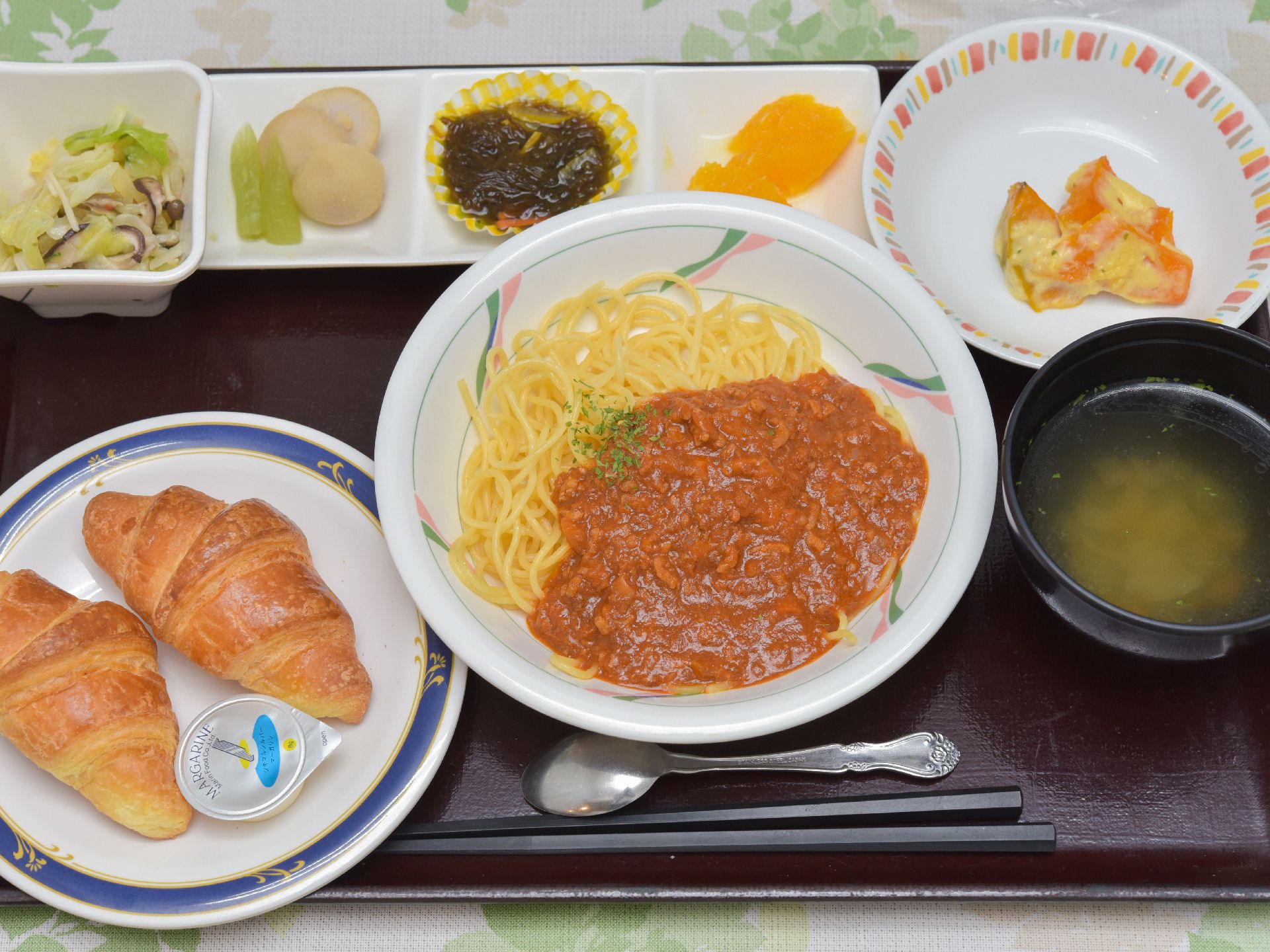 食事サービスの例。今回のメニューはクロワッサン2個、ミートソースパスタ、スープ、野菜の和え物、副菜3種など。
