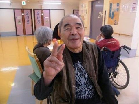 エレベーターホールの一角で、ピースサインをしている男性入居者様
