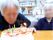 イチゴのお誕生日ケーキに、ろうそくを付けてお祝いしている。施設では、入居者様に喜んでいただけるイベントを開催している。