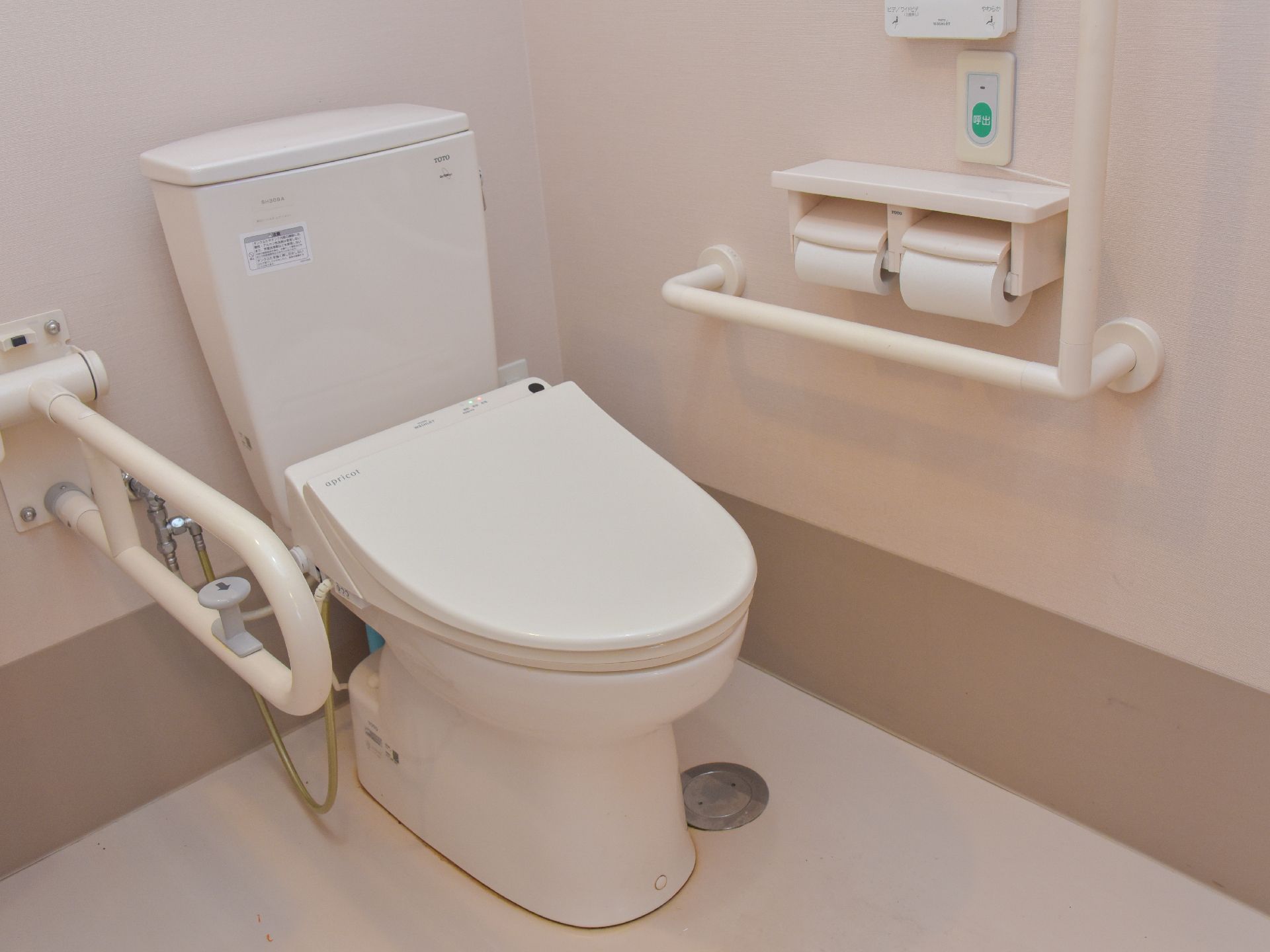 トイレは、全体的に白のデザインとなっている。緑の呼び出しと書かれたボタンや、手すりがあるので、安心して利用できる。
