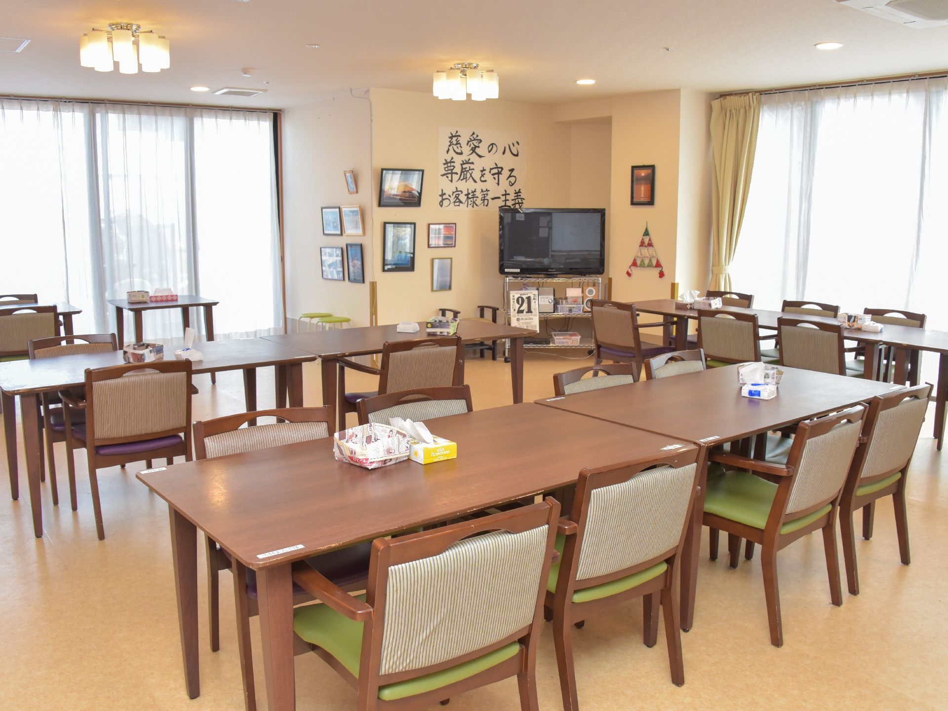 居間は、4人掛けの椅子やテーブルが複数セット用意されている。大きな窓からは、明るい光が溢れ出している。