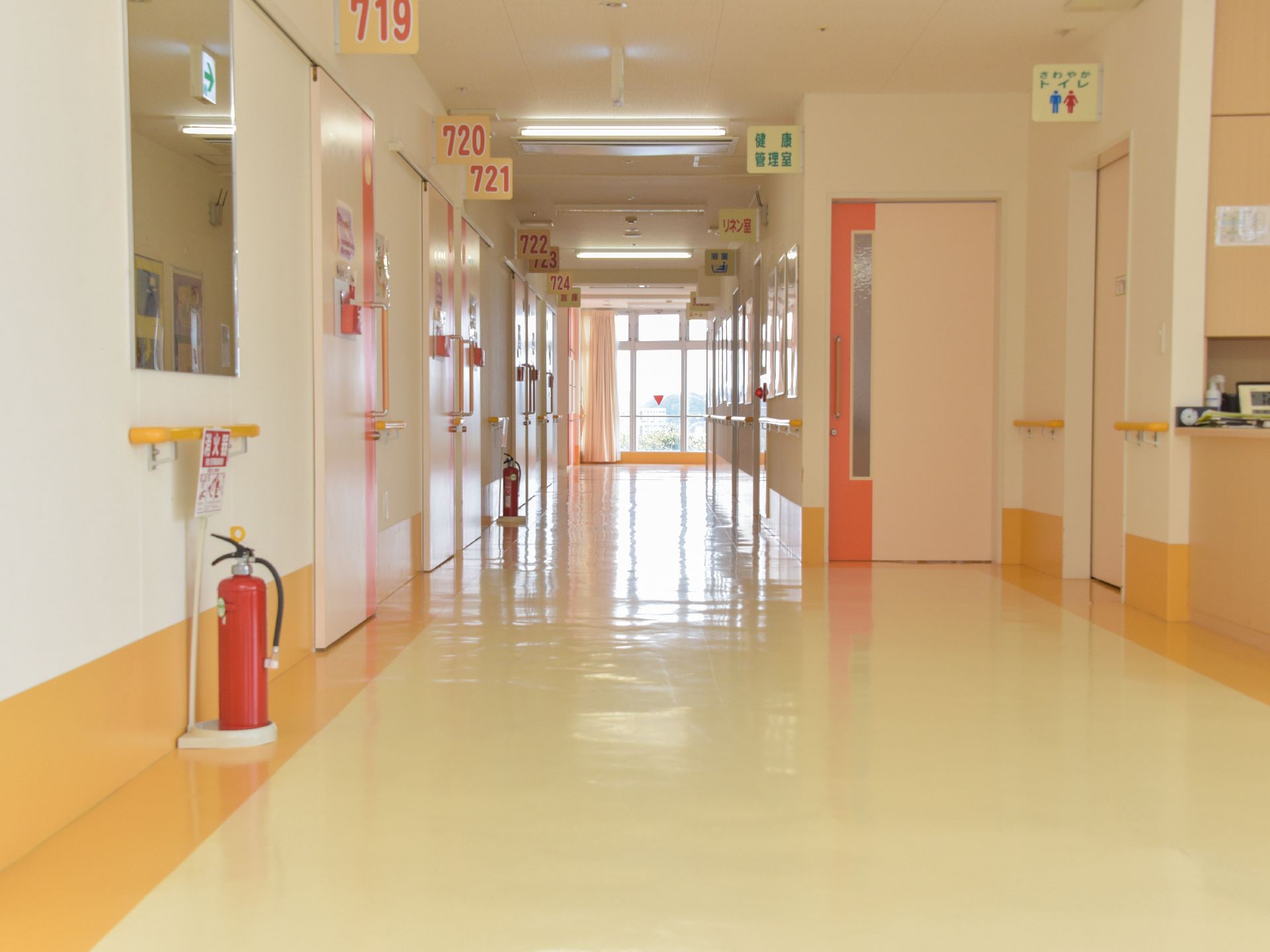 廊下は、壁に手すりがあるので、歩行が安全に行える。部屋番号やトイレの表記が大きく書かれており、分かりやすい。