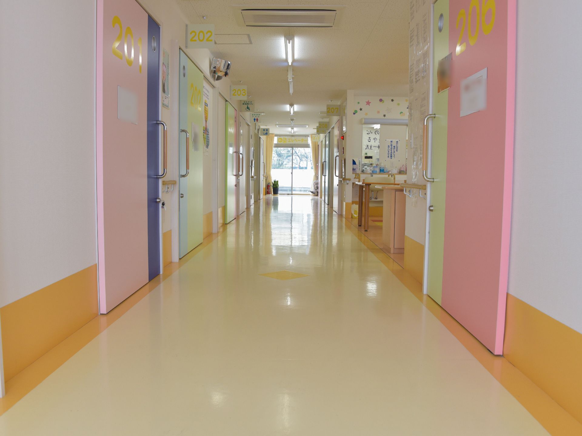 広い廊下には、明るい太陽の光が差し込んでいる。ピンクのドアには、部屋番号が黄色で書かれており、大変分かりやすい。