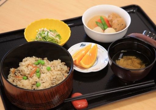 すまし汁と炊き込みご飯の間に、オレンジが置かれているお膳