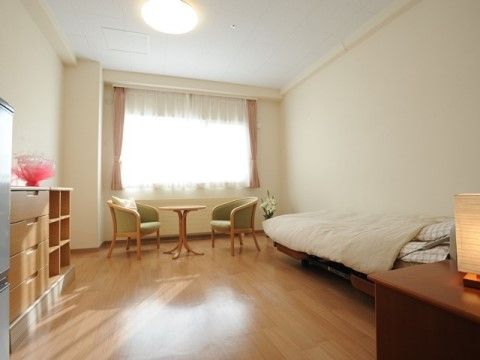 白い壁にあたたかな木の家具が設置してある。窓からは明るい光が差し込んでいる。床は家具と同じあたたかな色のフローリングである。