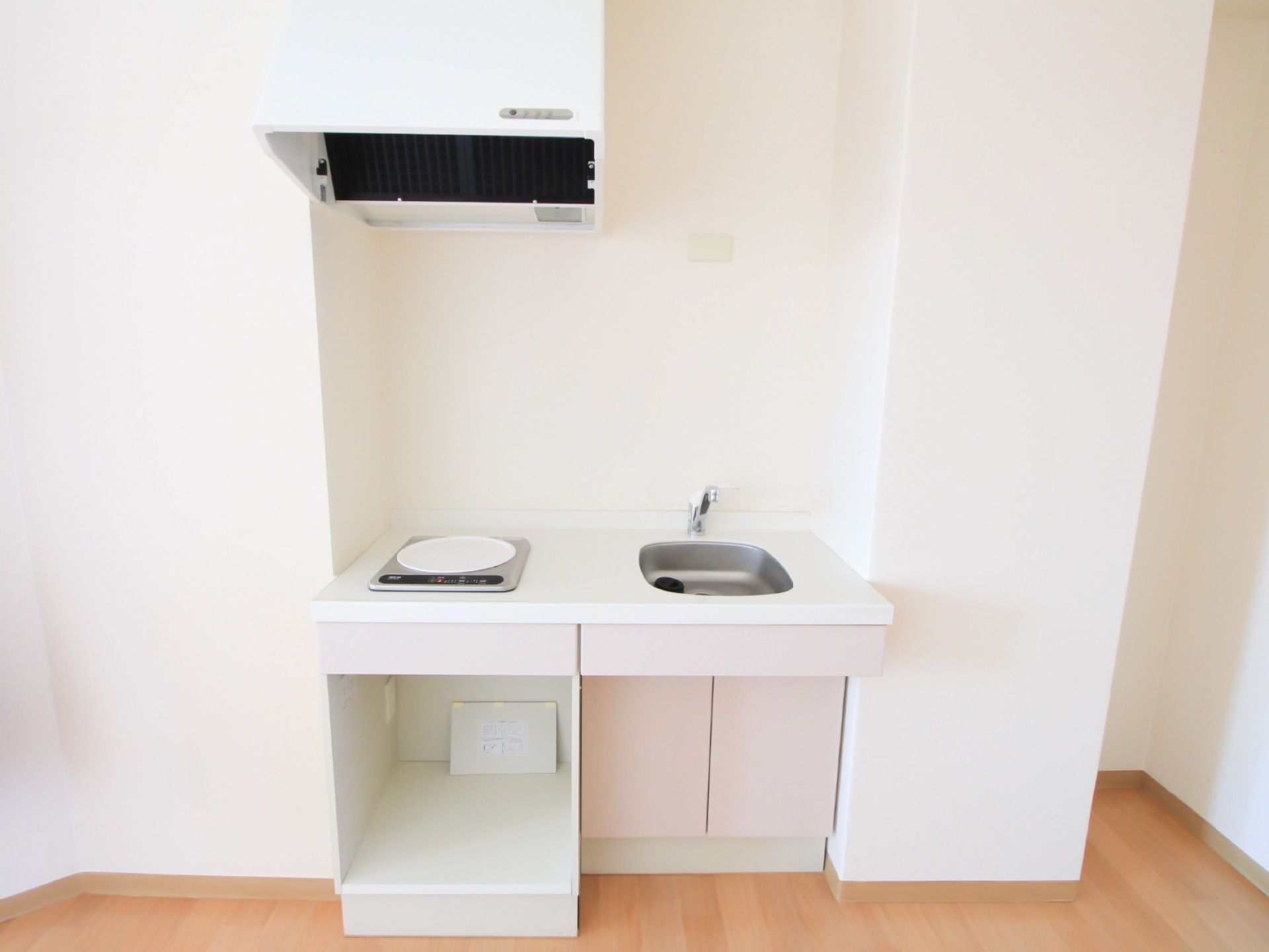 居室にはミニキッチンが設置されている。電磁調理器に換気扇、コンパクトなシンクが設けられ、収納スペースも用意されている。