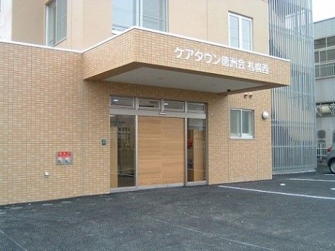 施設は、茶色いレンガで統一された外壁の外観となっている。玄関前の屋根には、白い文字で施設名が書かれている。