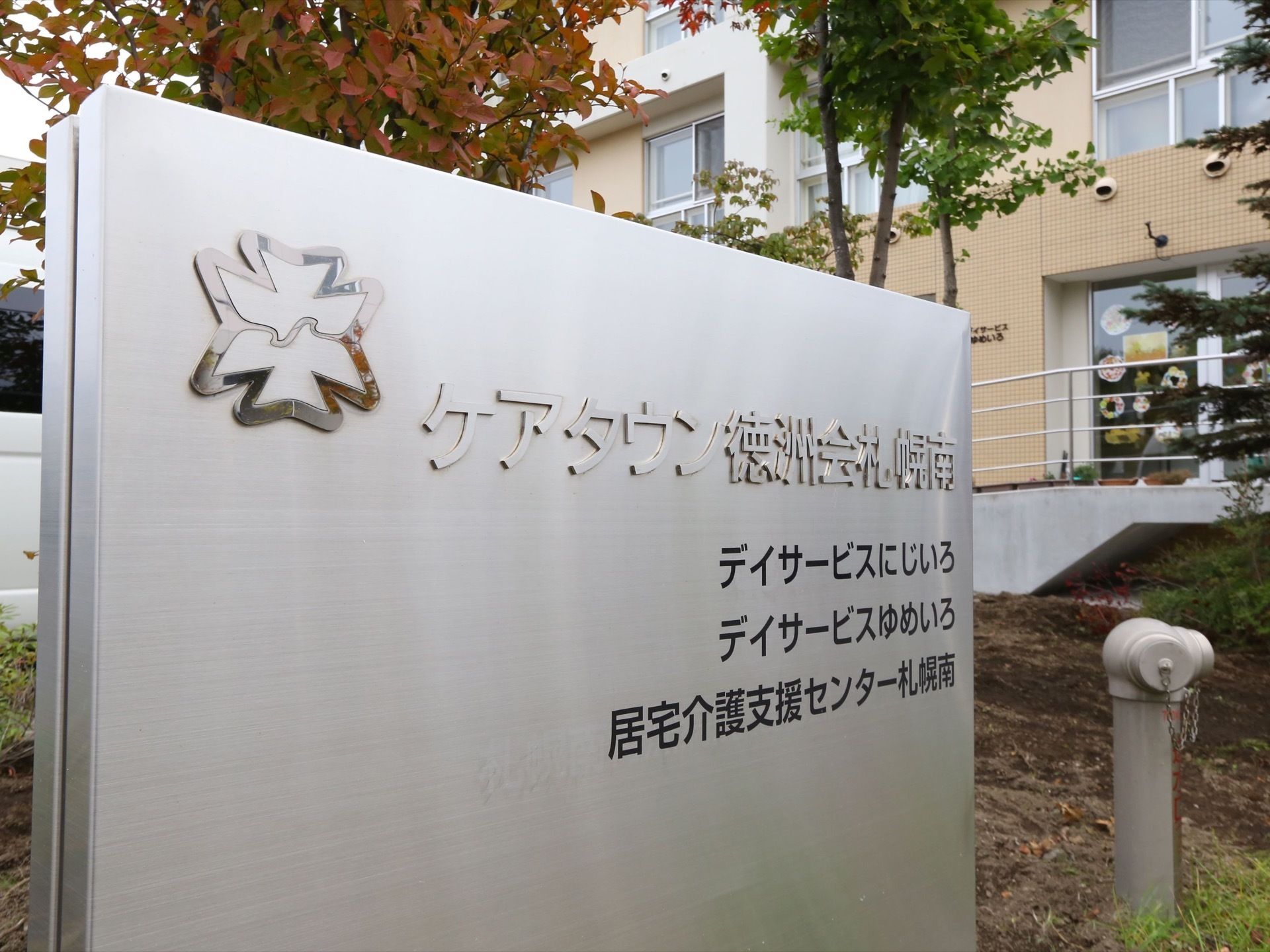 シルバーの大きな板に、施設名が浮き上がる形で記されている。敷地内にある複数のサービス施設についても明示されている。