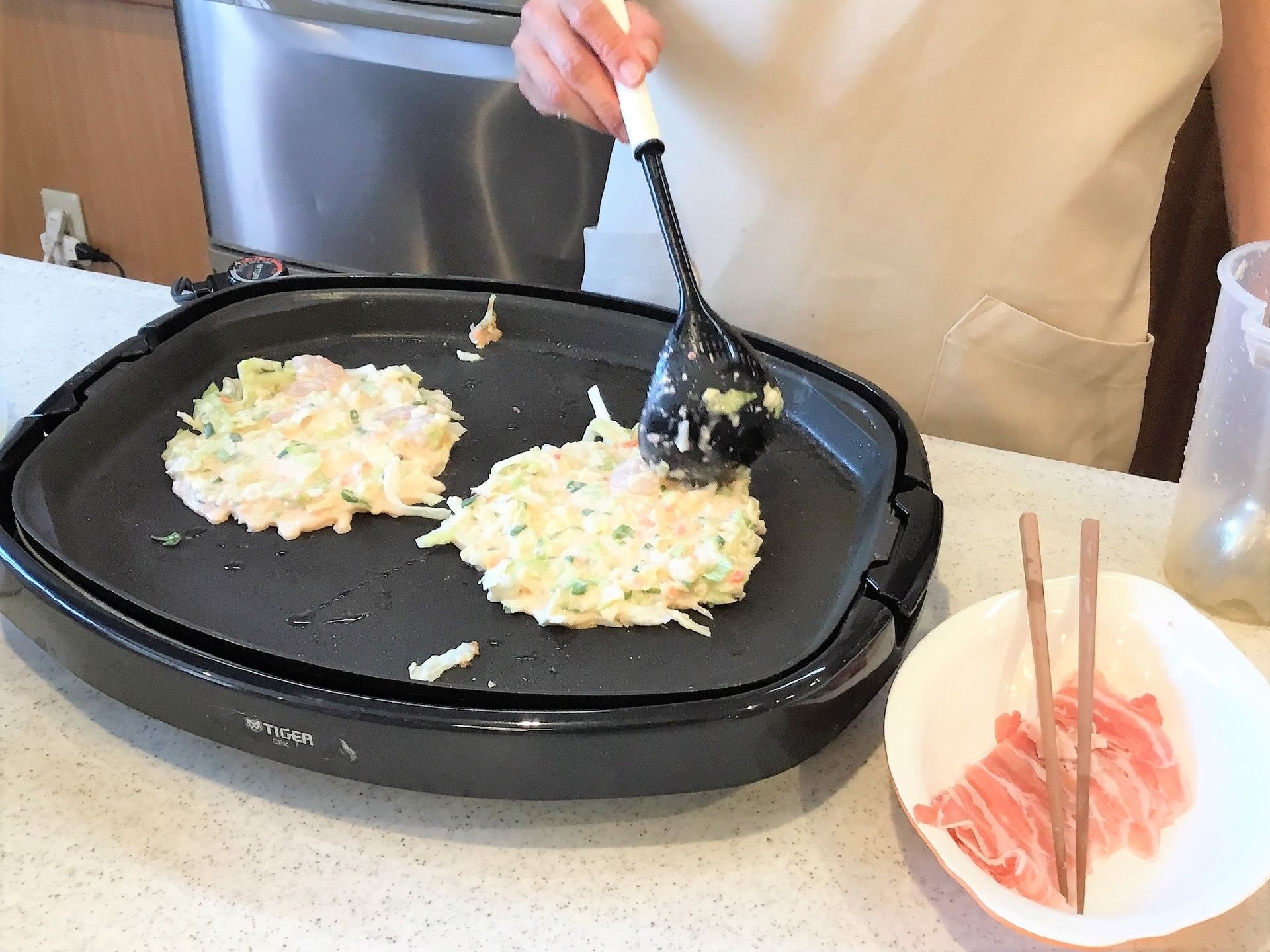 ホットプレートでお好み焼きを焼く様子