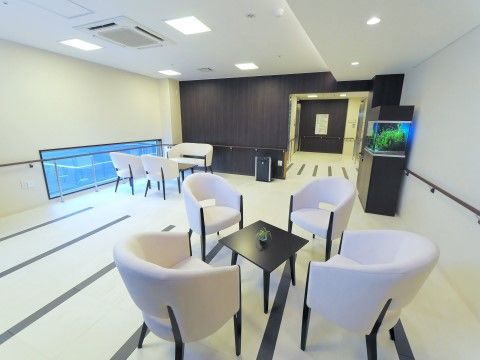 広いロビーには水槽が置かれ、隅にはテーブルとソファも備えてある。モノトーンの室内に水槽と窓ガラスの水色が映える、モダンな空間になっている。