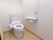 部屋のトイレは、ウォシュレットを完備。開閉の手間を省くため、便座の蓋を撤去してある。壁面にはコールブザーを設け、安全担保に配慮。