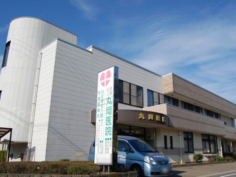建物の前に駐車スペースがあり、玄関前にルーフが付いた二階建ての病院