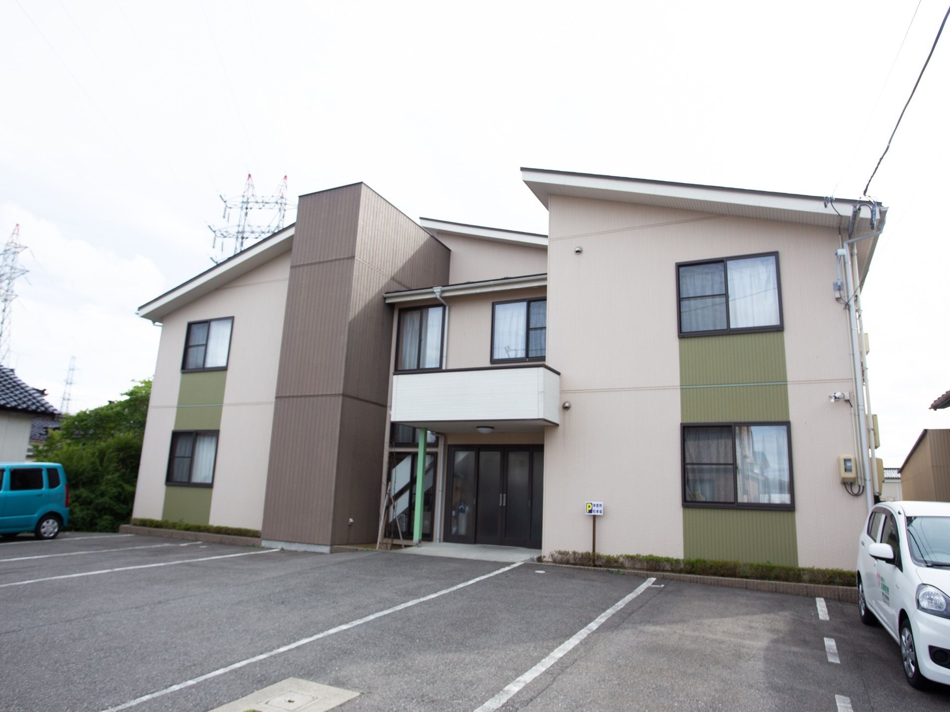 白色を基調として、所々に緑や茶色が使われている外壁の２階建ての施設である。玄関前には照明器具がついたひさしがある。