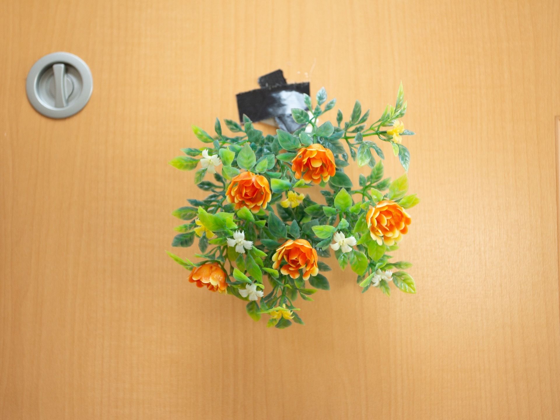 オレンジ色のお花をドアの外に貼り付けて、温かみのあるカラーをプラスしている。お部屋や共用の空間が明るくなるように、飾りを置いている。