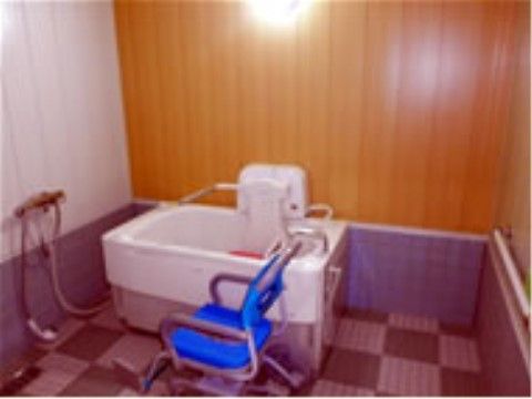 「シニアガーデンそよかぜ3号館」の機械浴室。介助スタッフが入居者様の支えになり、入浴を可能にしている。
