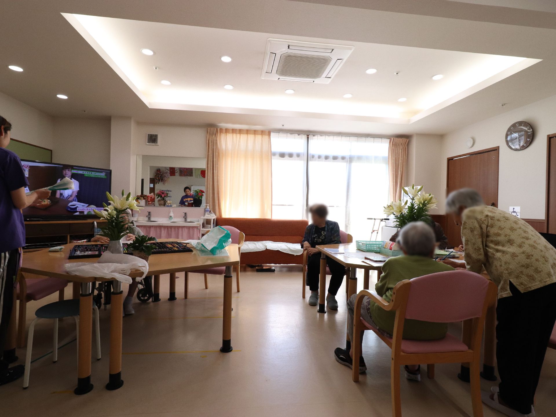 居住者の為の共用スペースが設けられ、会話をしたり、思い思いの行動をしている。ソファも置かれ、くつろぎの場になっている。