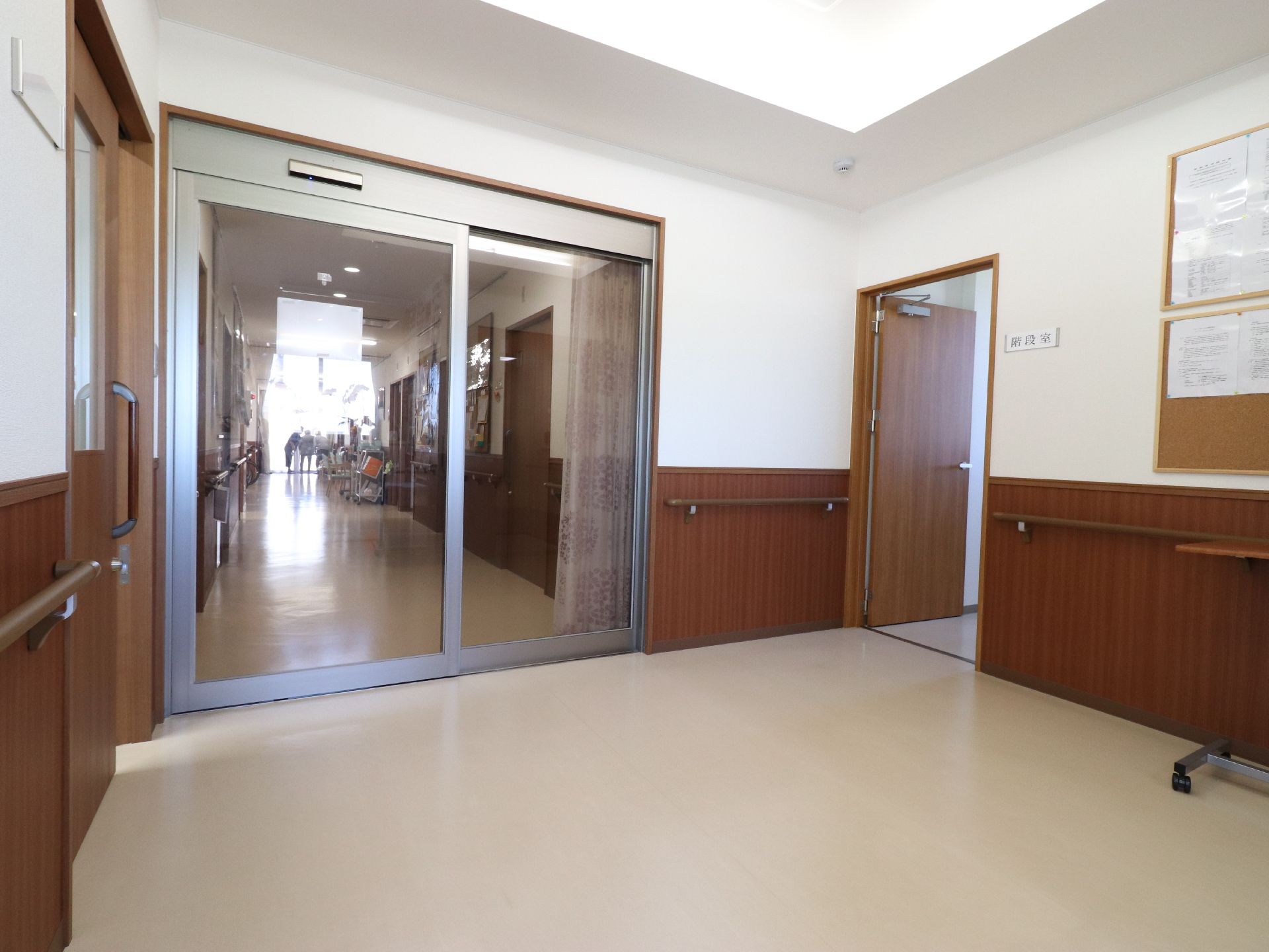 入居者の個室へつながるホールは自動ドアで仕切られている。入居者のプライバシーを保てるよう外部から見えないようにカーテンが設置されている。