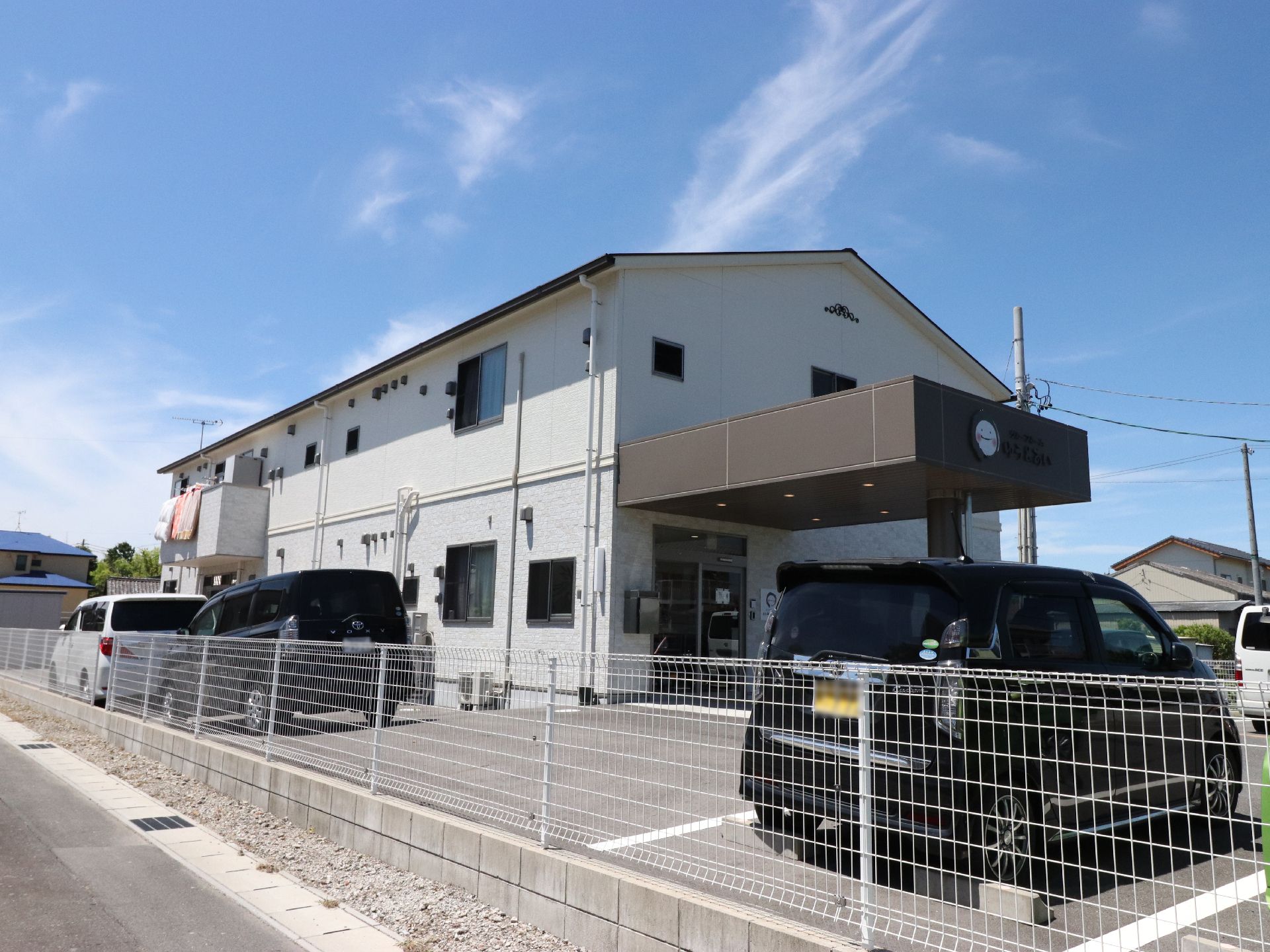 施設のエントランスを出ると駐車場がある。施設の外は整備された道路で周辺は閑静な住宅地であり散歩するには便利。