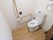 明るいトイレの右側には天板が白色のカウンターが設けられており、トイレットペーパーなどの用品類を置くことができる。