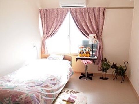 電動昇降付きのベッドが１台置かれている。その他、エアコンが設置されており、くもりガラスの窓にカーテンが取りつけられている。