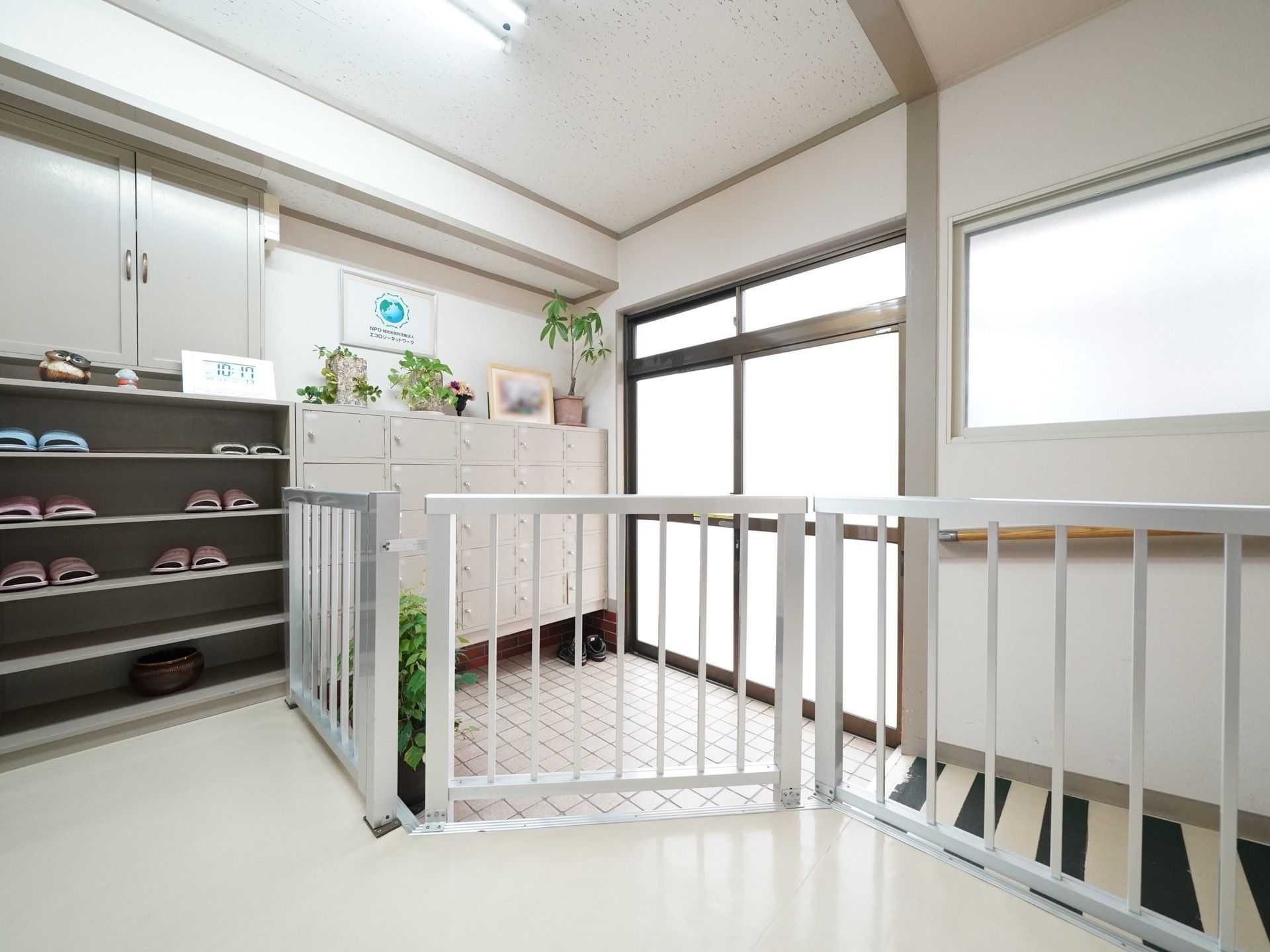 玄関は引き戸で、扉のついた靴箱が置かれている。可動式の柵を入ると、スリッパの並べられた棚が置かれている。