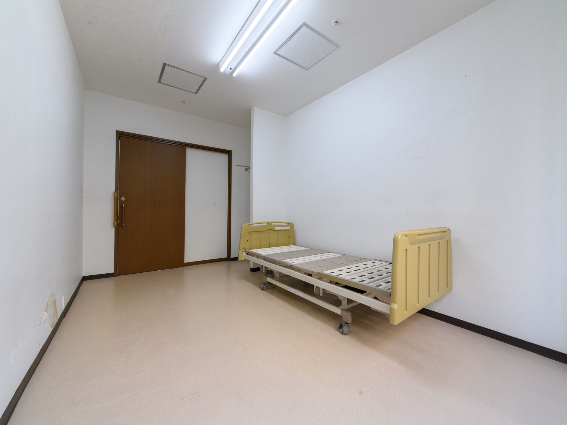 居室の入口は大きな持ち手が付いた引き戸になっている。ベッドを置いてもゆとりのある広さが確保されている。