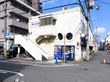 施設に面した道路は交通量が少なく、一方通行となっている。建物の１階にはテナントが入り、２階が居住施設になっている。