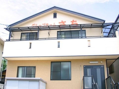 「グループホームさち」の外観。木造2階建ての一軒家の住宅の外観を施した、グループホームである。