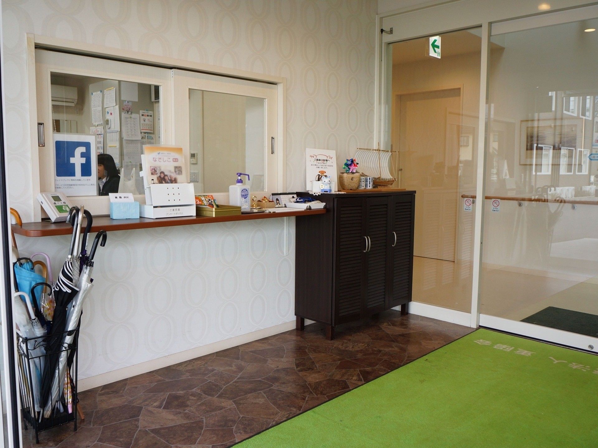 部屋の一角で、二列に並んでほほえんでいる十名以上のスタッフたち