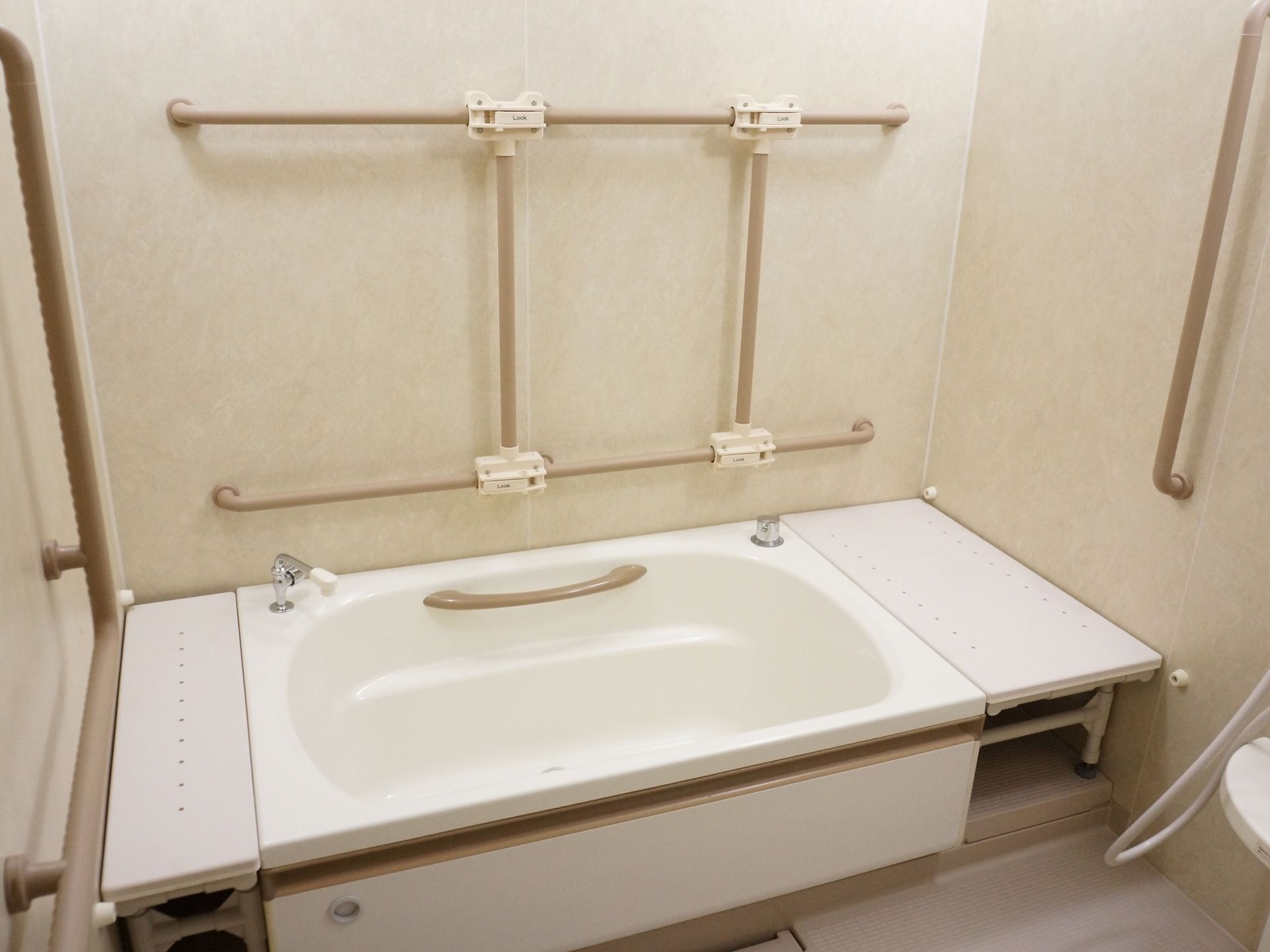 浴室は清潔感があり、明るい空間である。浴槽内やその周りの壁に手すりが設置されており、安全に入浴することができる。