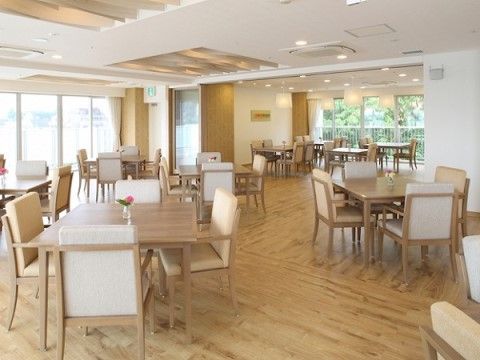 かなり広さのある部屋で、床はフローリングになっている。木目調のダイニングテーブルと椅子のセットがいくつも置いてある。