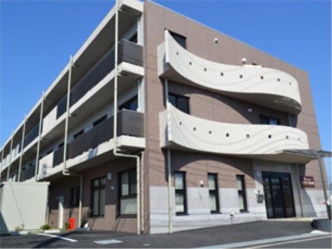 玄関前のスペースがゆるやかなスロープになっている、施設の外観