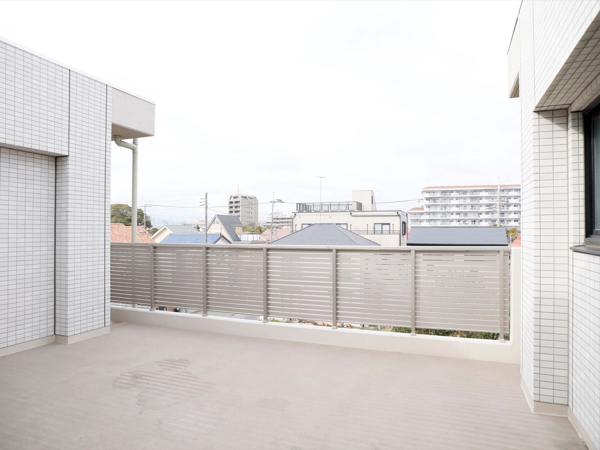 施設3階部分にある広々としたルーフバルコニー。転落防止の銀色の高い柵が付いている。外の景色を楽しむことができる。