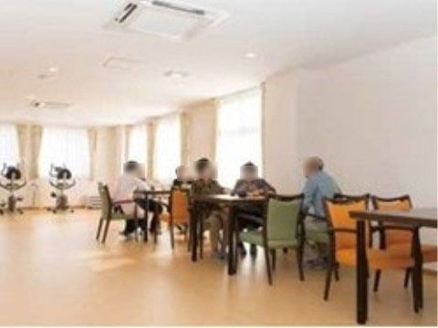 リビングに設置されているテーブルセットに座り、歓談している入居者様たち