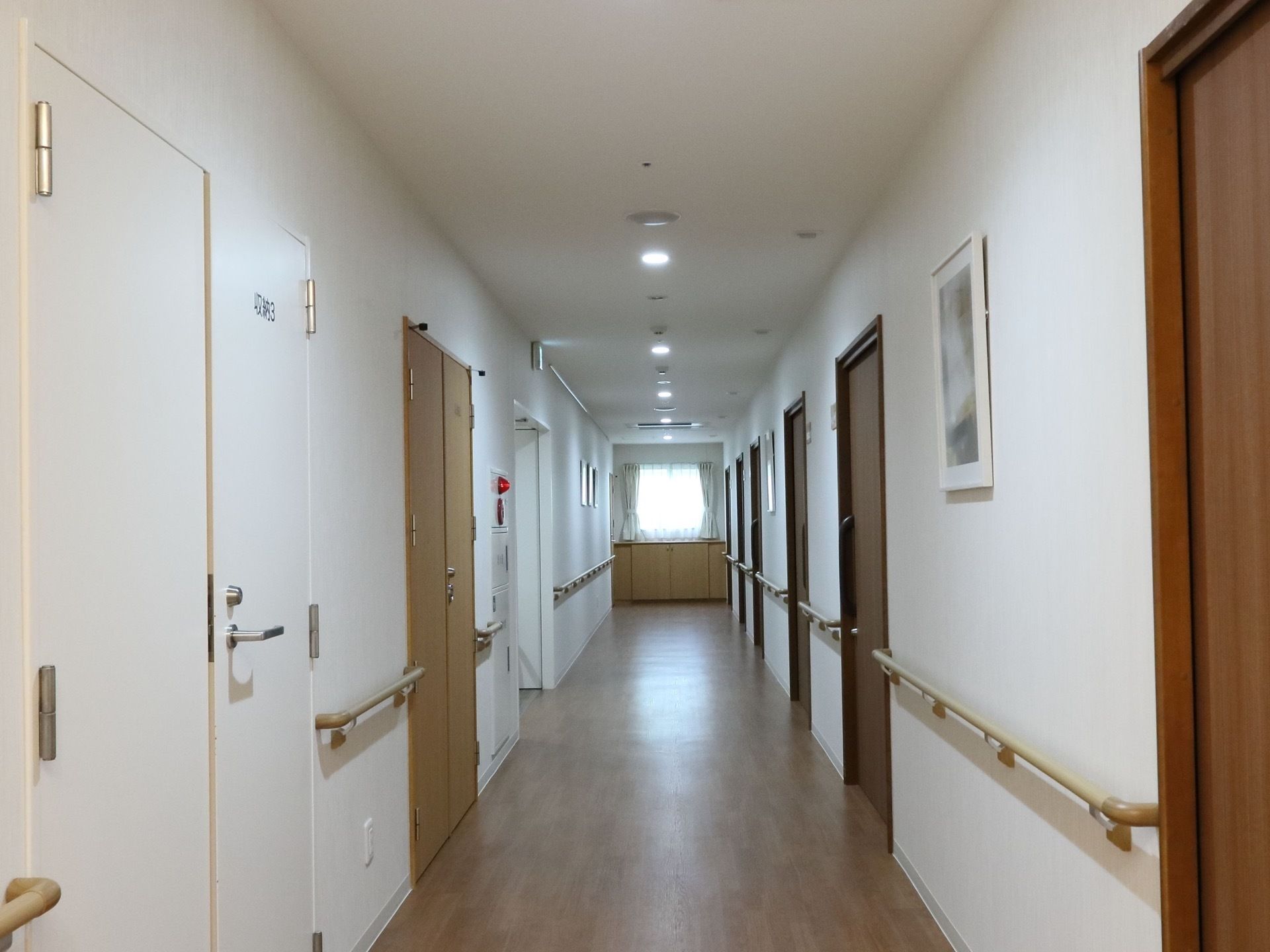 白が基調のシンプルな通路である。段差はなくバリアフリーで、通路の壁に沿って手すりも取り付けられている。