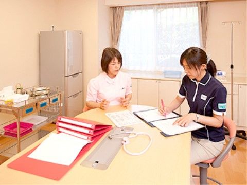 テーブルに着き、ミーティングをしている二名の女性スタッフ
