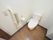 居室のトイレは白壁にフローリングの床。ウォシュレットのついた白い水洗トイレが一つ設置されている。壁にはペーパーと呼び出しスイッチもある。
