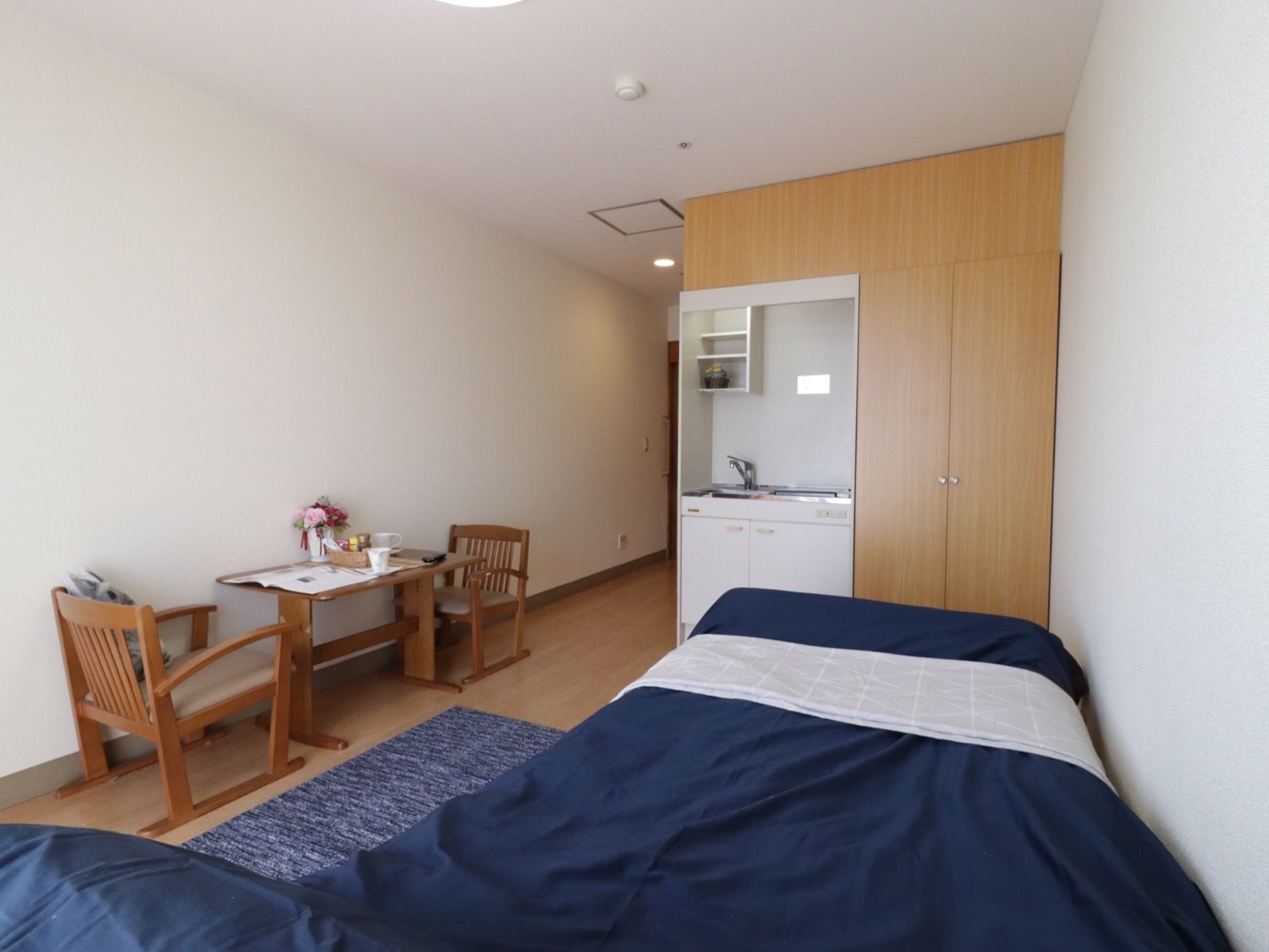 居室には、ミニキッチンと収納スペースがある。コンロは１口あり蛇口はハンドルタイプを採用している。収納は両開きタイプの扉である。